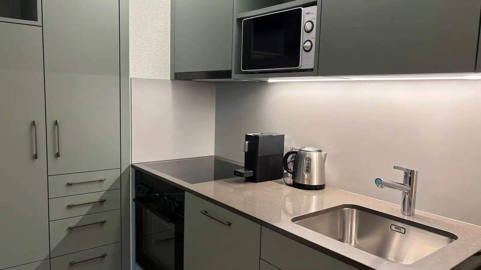 Küche mit Backofen, Mikrowelle und Kaffeemaschine